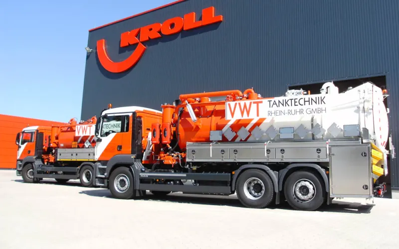 Tank cleaning vehicle with multi-compartment body in front of the KROLL plant, a second vehicle behind it