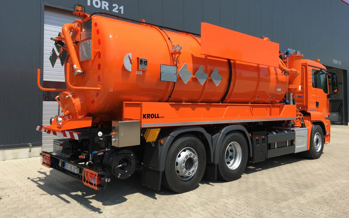 Orange KROLL vacuum truck on a three-axle chassis, rear view in front of the KROLL hall