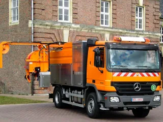 Orange high-pressure jetting vehicle from the front, slewing reel boom in travel position