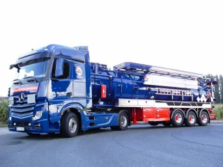 Blue vacuum semi-trailer combination, side view from the front