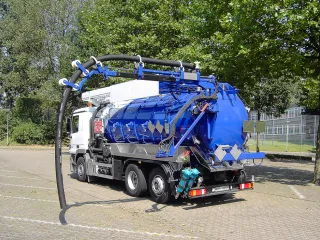 Blue vacuum truck with suction boom and suction hose, rear view