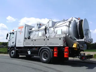 Multi-compartment vacuum truck with stainless steel tank and storage boxes, side view