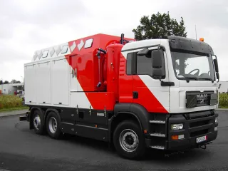 Red and white box body of a tank cleaning vehicle on a three-axle chassis